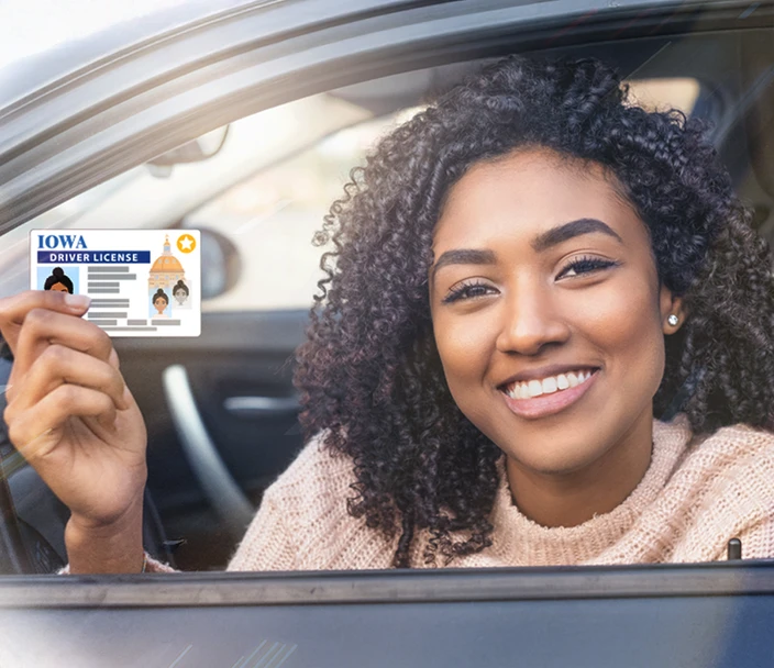 Woman holding her driver's license with a REAL ID gold star